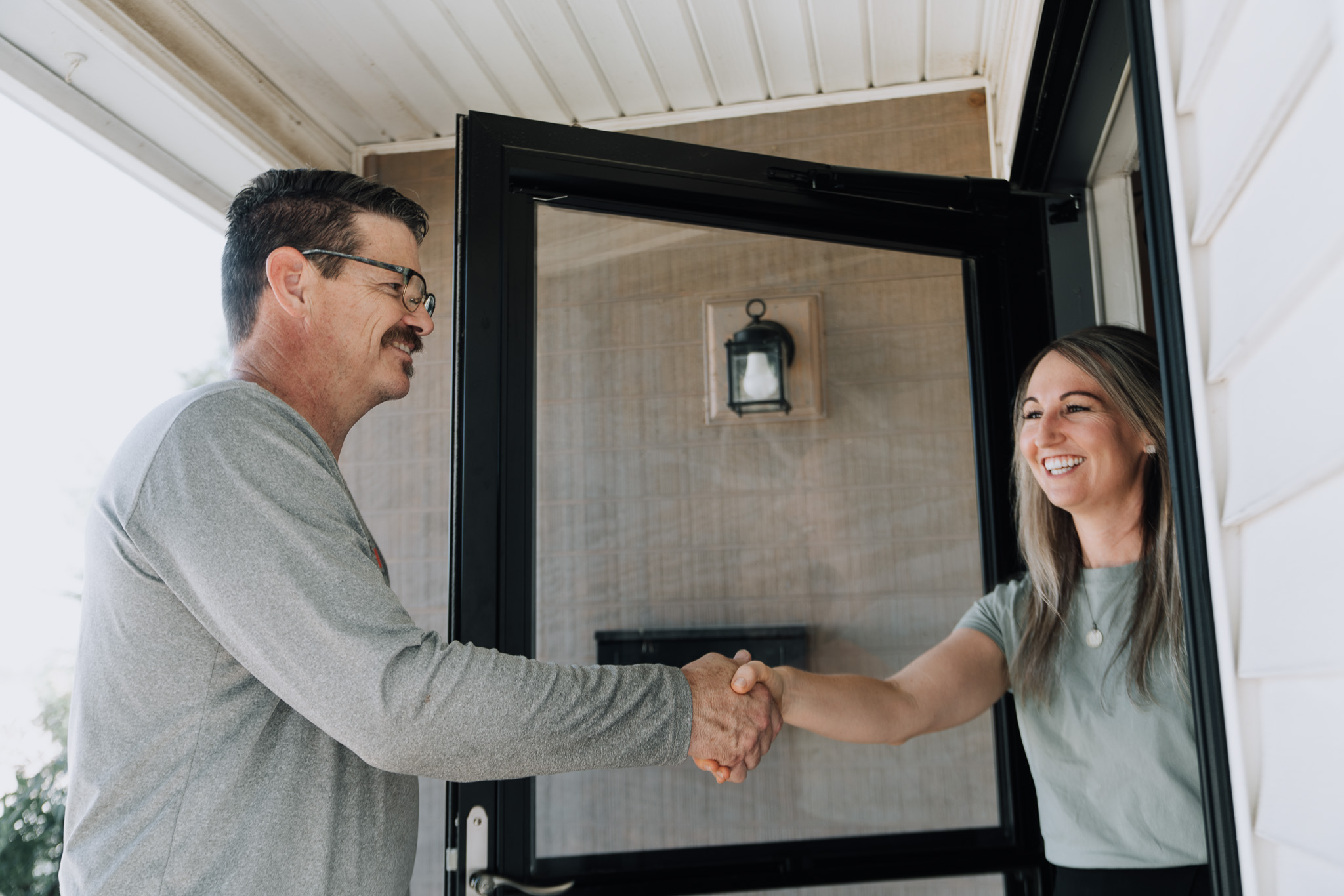 Sniper technician greeting a happy customer at their front door